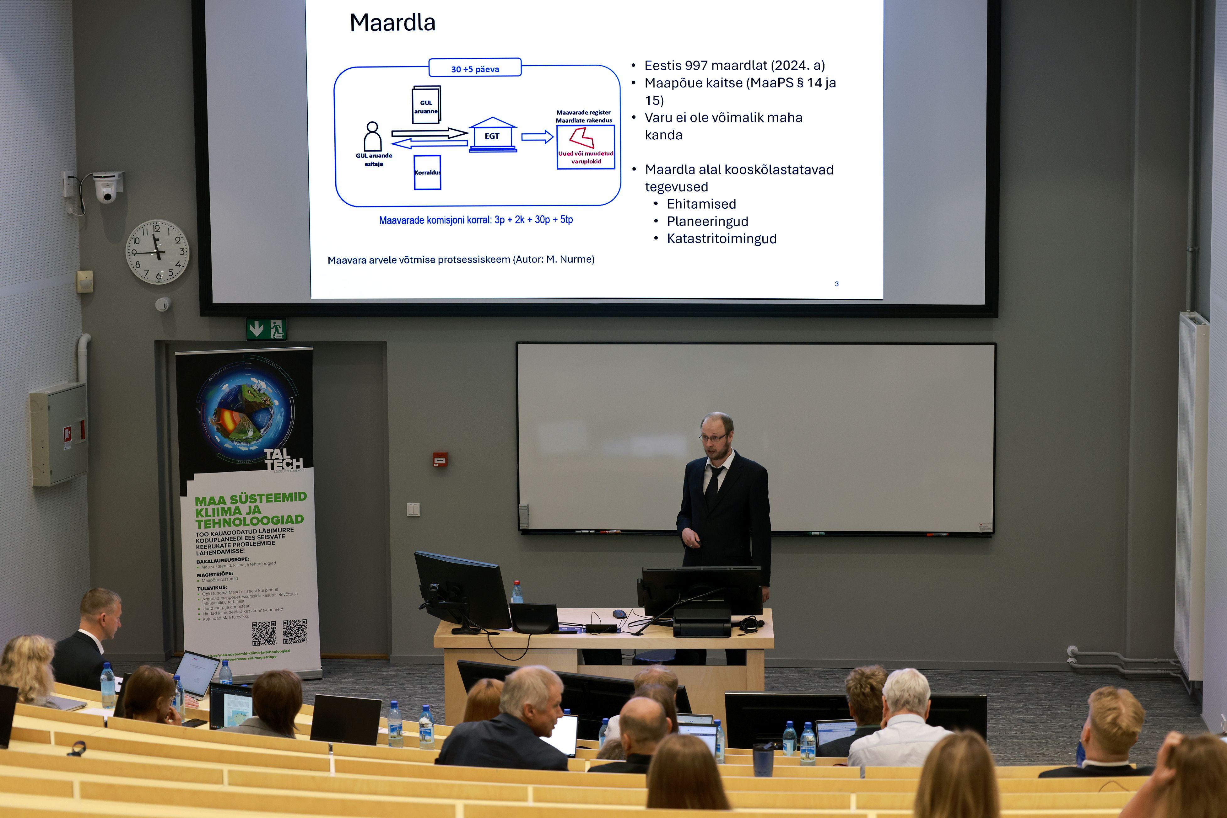 man in suit speaking to an audience