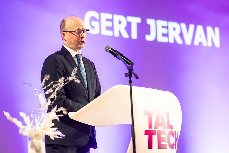 TalTechi IT-teaduskonna dekaan Gert Jervan kõneleb poodiumil stipendiumide üleandmise üritusel. Taustal on TalTechi visuaal ja saalis viibiv publik.